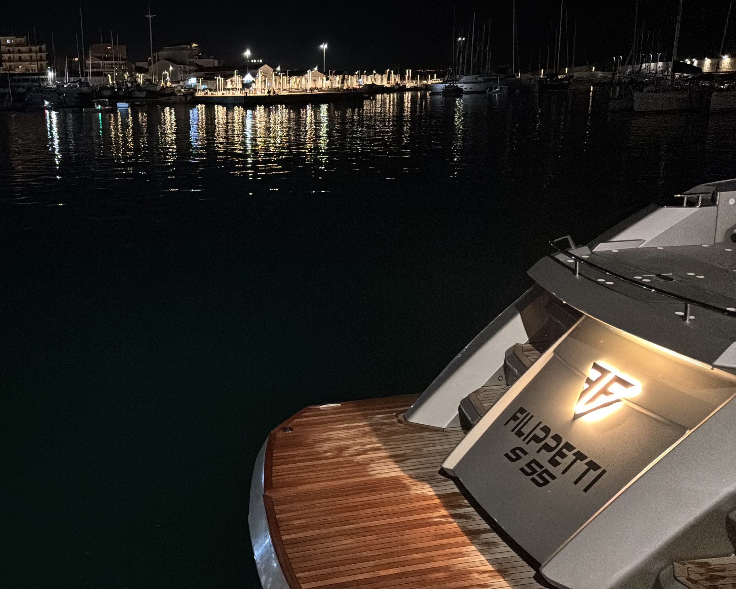 Poppa illuminata dello yacht Filippetti S55 ormeggiato di notte, pronto per la partenza della rotta di collaudo di 1200 miglia.
