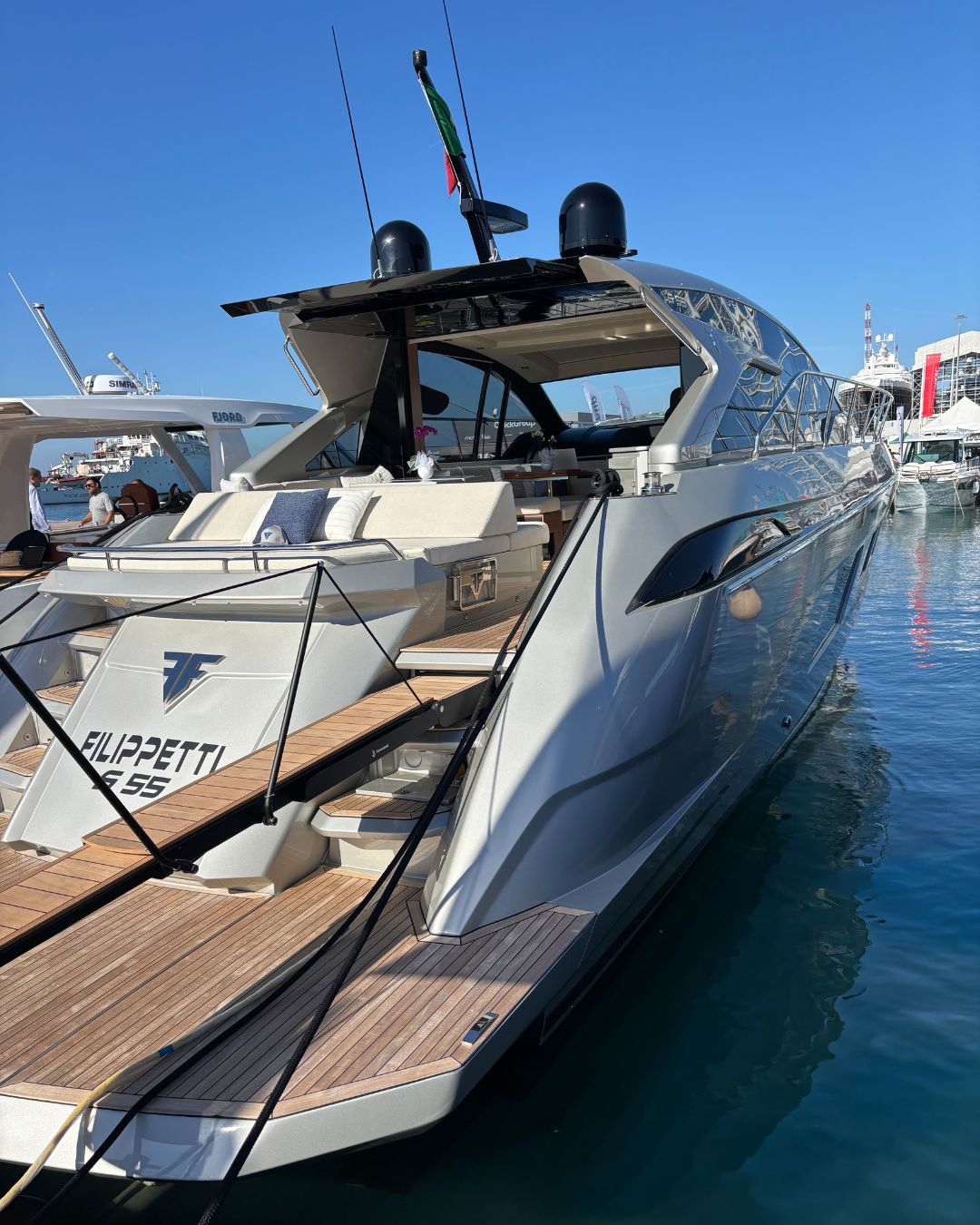 Vista di poppa e piattaforma da bagno in teak dello yacht Filippetti S55 in esposizione al Salone Nautico di Genova 2025, sotto il sole.